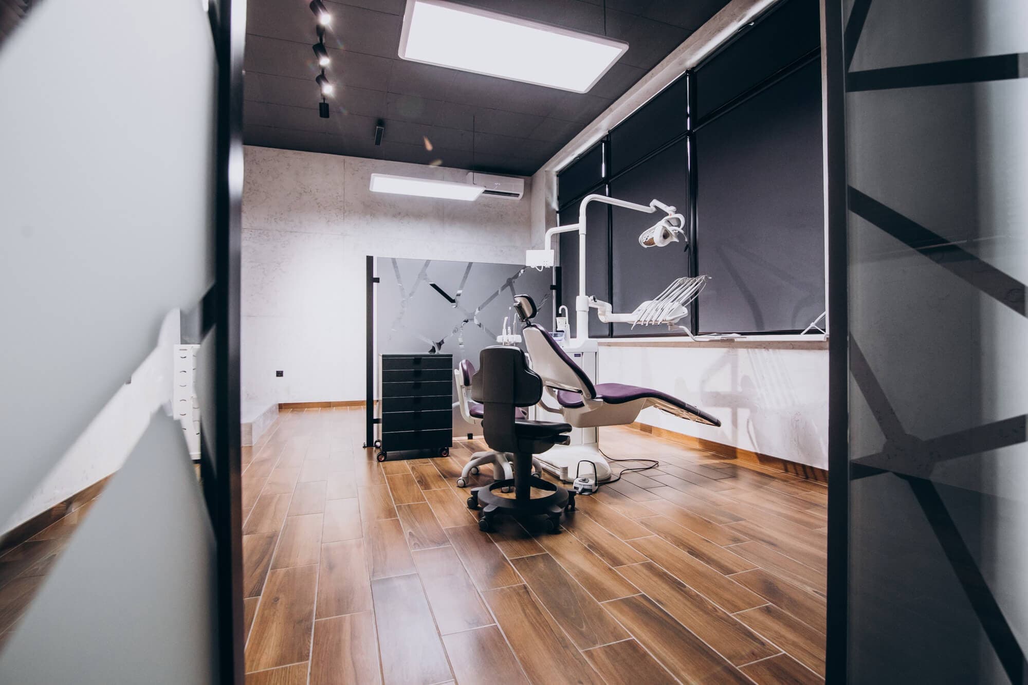 A dental office featuring a patient chair and a desk, designed for dental examinations and treatments.
